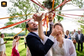 At Château de Millery-Autun, the groom and bride cut the bouquet's ribbons, symbolizing a moment of togetherness and joy.